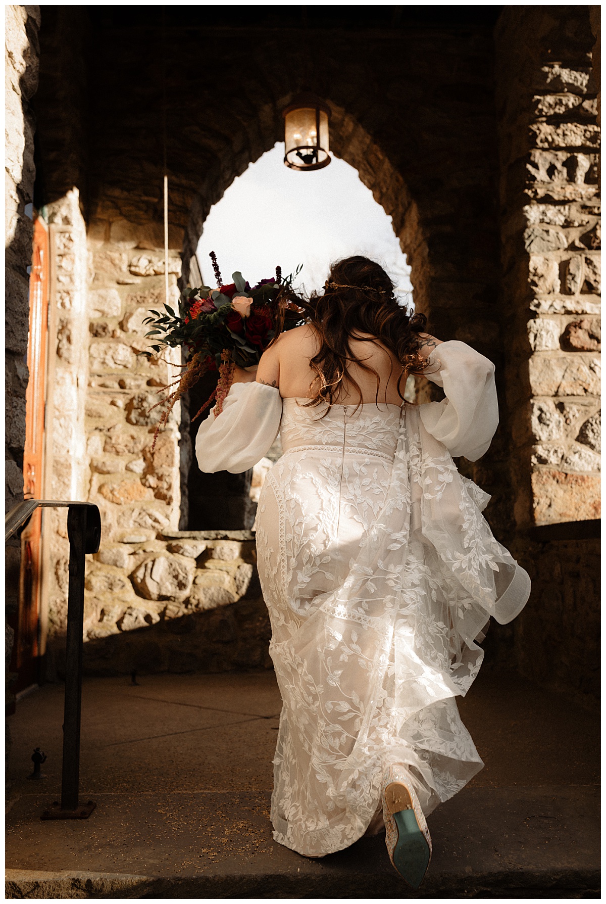 bride climbs stairs at stone church during whimsical ridgetop wedding 