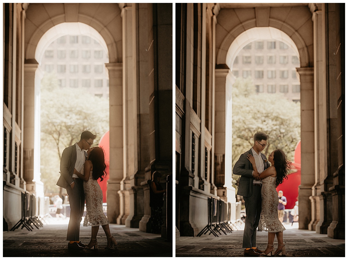 couple kisses under archway near NYC City Hall